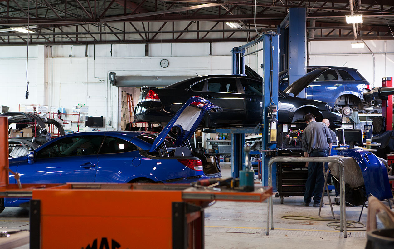 inside schaefer autobody center, people repairing vehicles