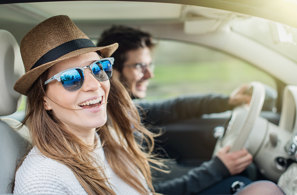 young adults driving in car smiling