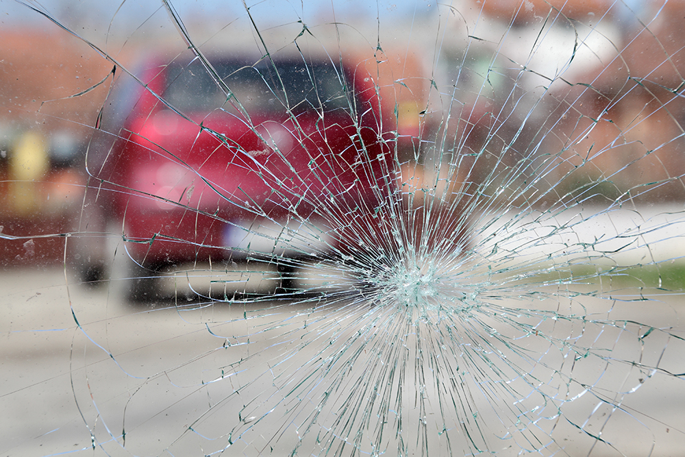 | Schaefer Autobody Centers car blurred through cracked windshield