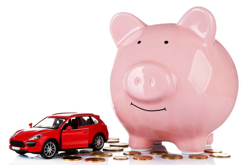 piggy bank next to small toy car surrounded by change