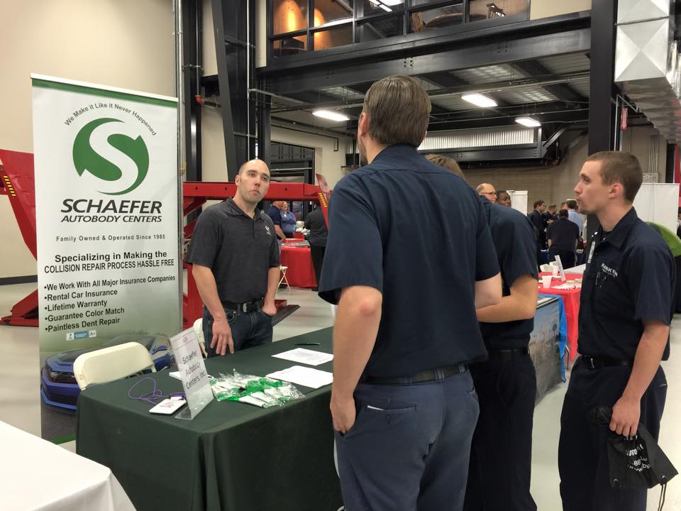| Schaefer Autobody Centers schaefer employees standing around a table at a career fair