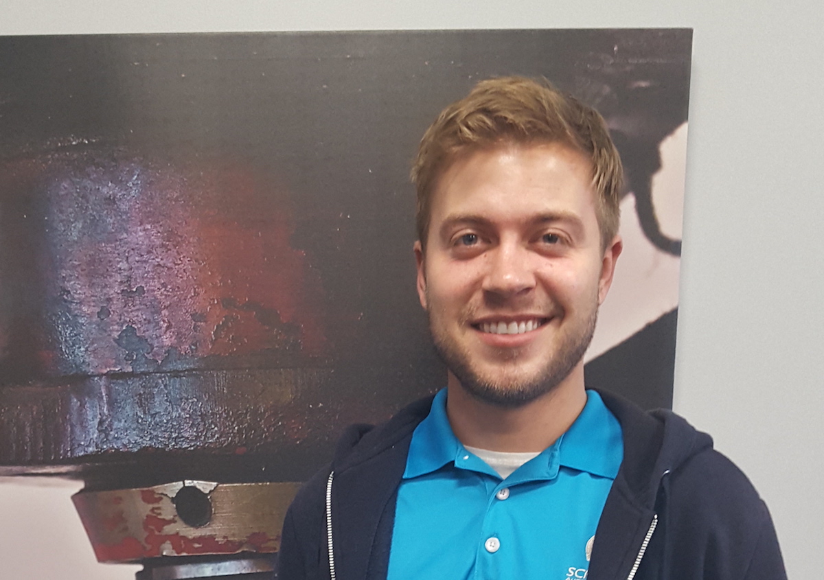 | Schaefer Autobody Centers tyler smiling standing in front of large metal piece of car