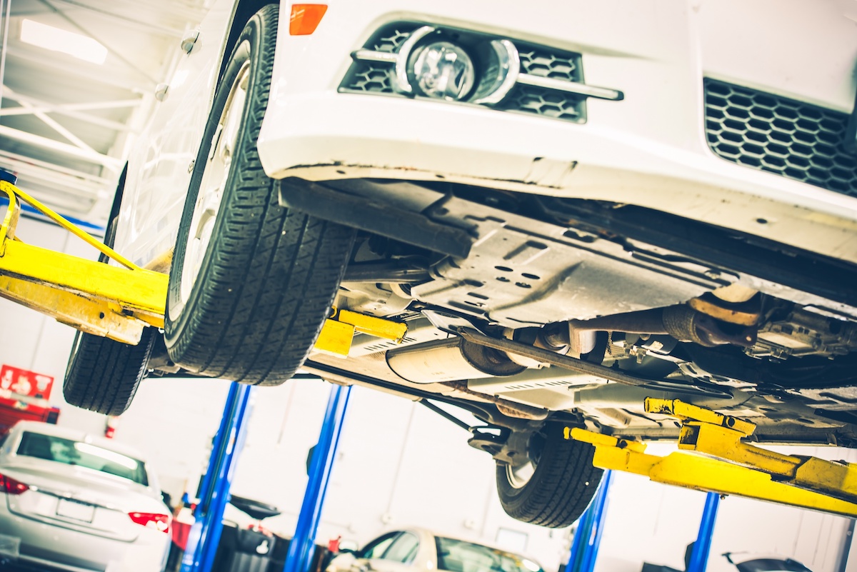 | Schaefer Autobody Centers Lifted Car Maintenance. Servicing Car on the Car Lift. Auto Service Theme.