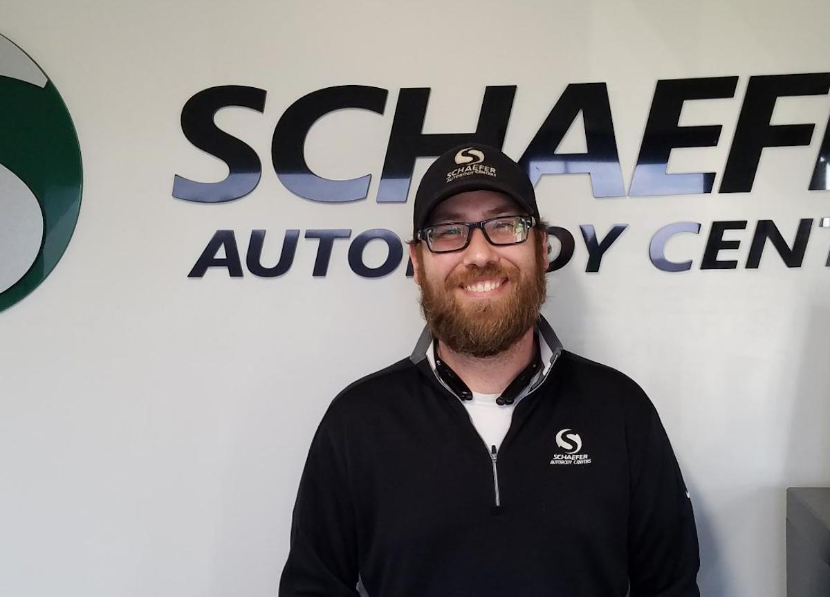 chris standing in front of schaefer autobody centers signage