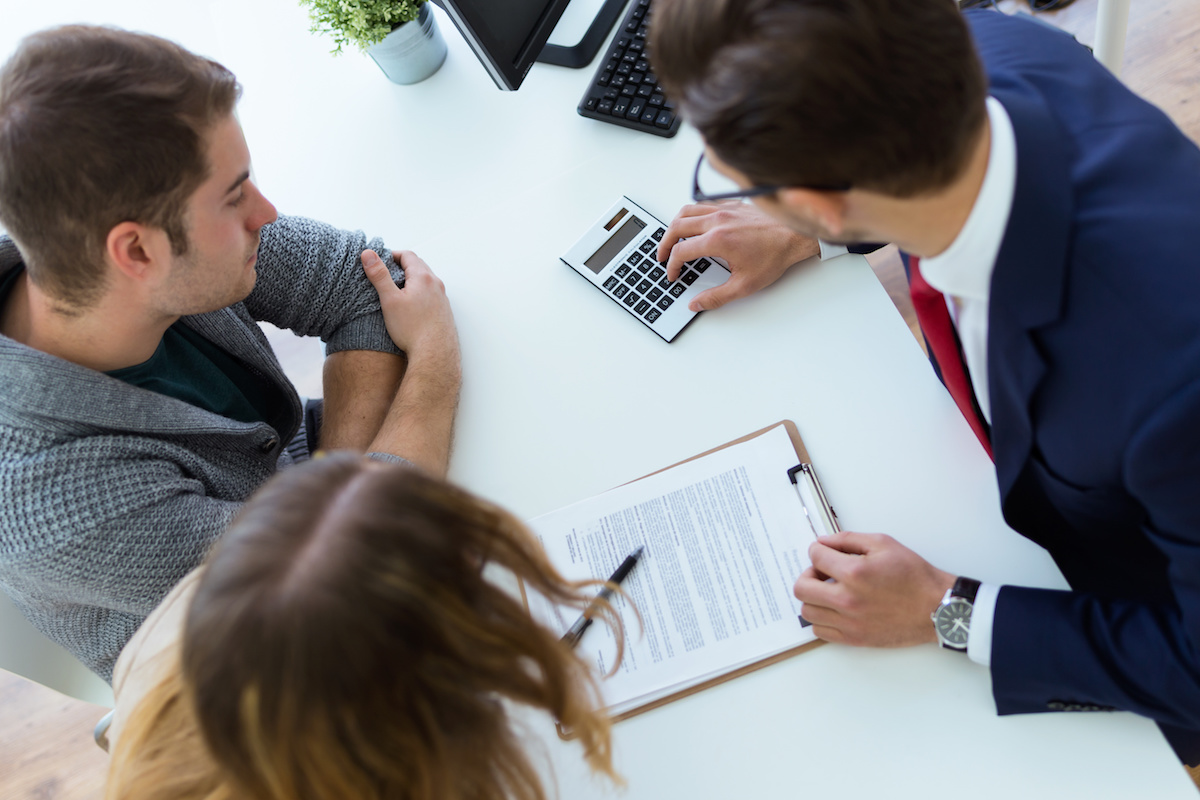 | Schaefer Autobody Centers Portrait of business young man explaining terms of contract to his clients in the office.