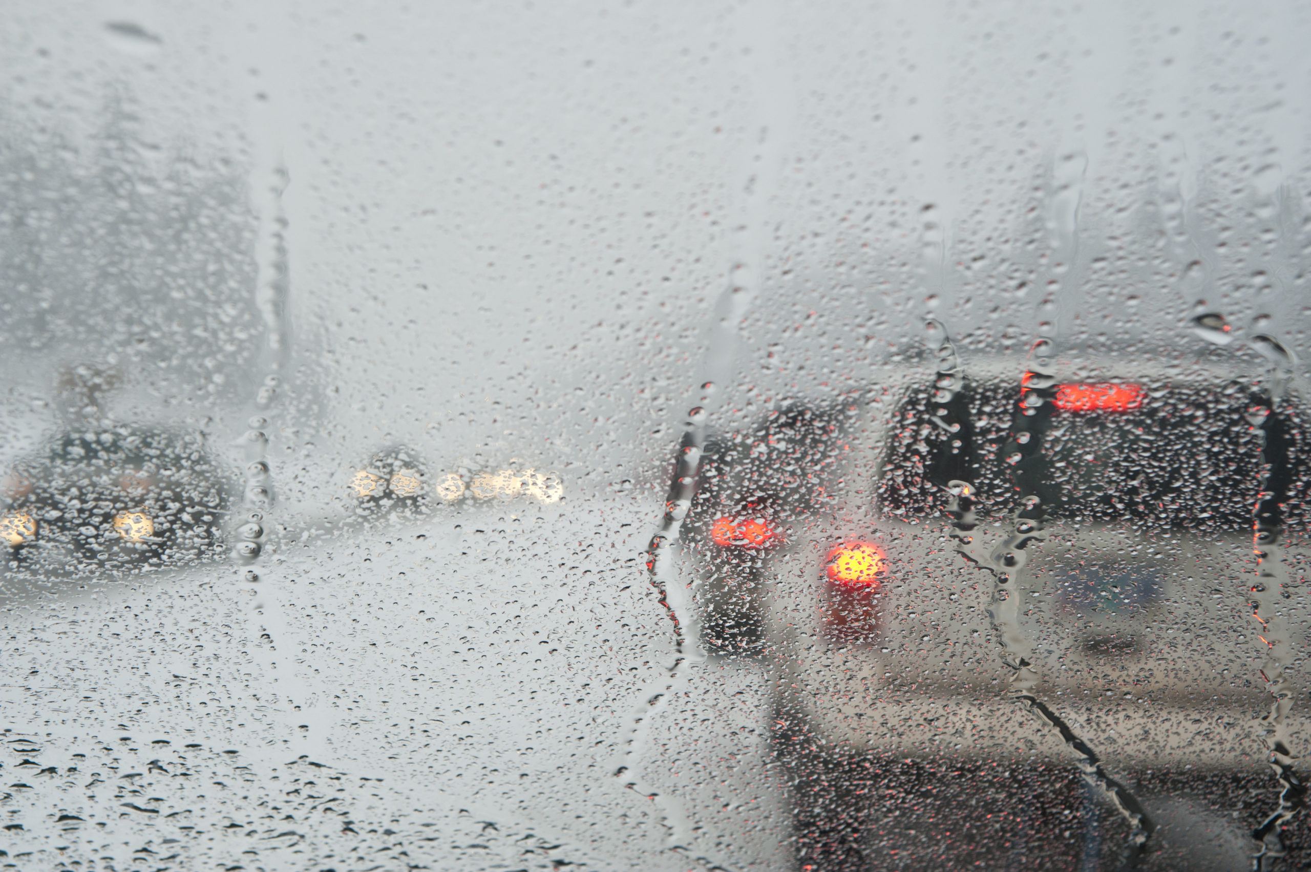 Winter traffic jam seen through a wet windshield