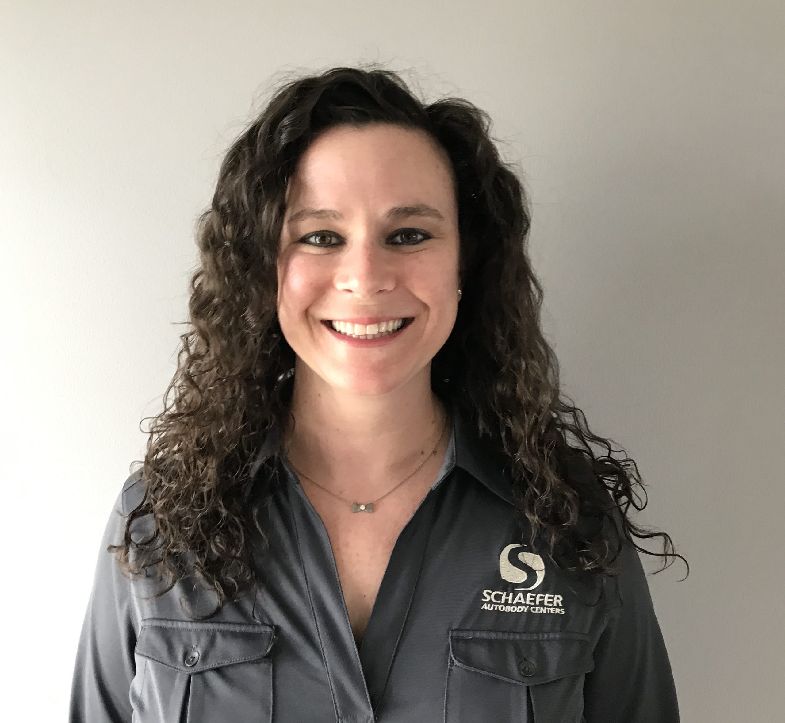| Schaefer Autobody Centers kristen smiling in front of white wall