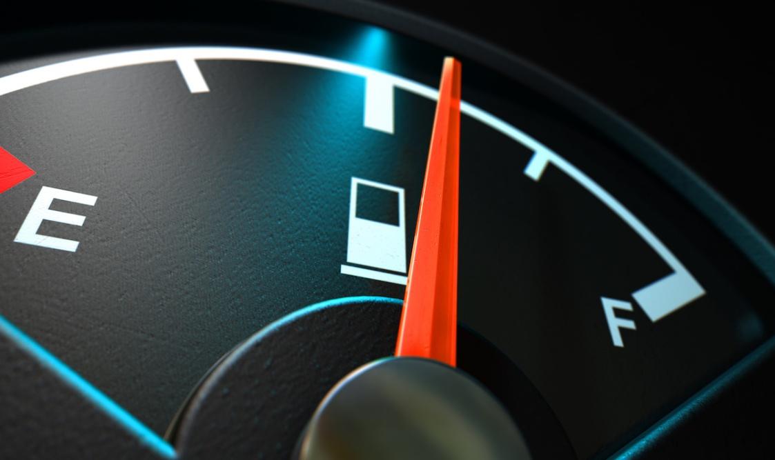 | Schaefer Autobody Centers A closeup of a backlit illuminated gas gage with the needle indicating a half full tank on an isolated dark background