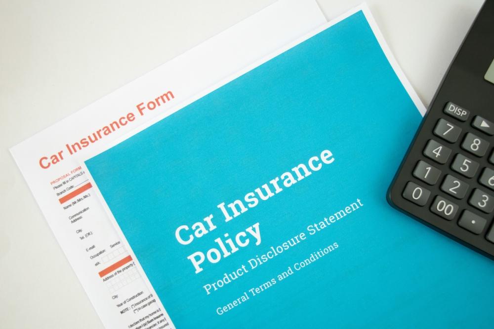 Top view of Car insurance concept with car insurense policy, form and calculator on a white background