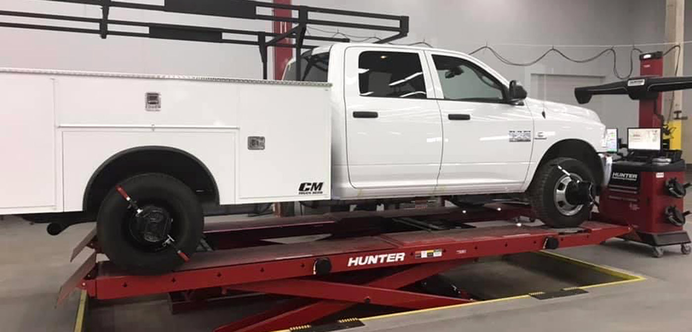 Fleet vehicle up on a scissor lift to be serviced.