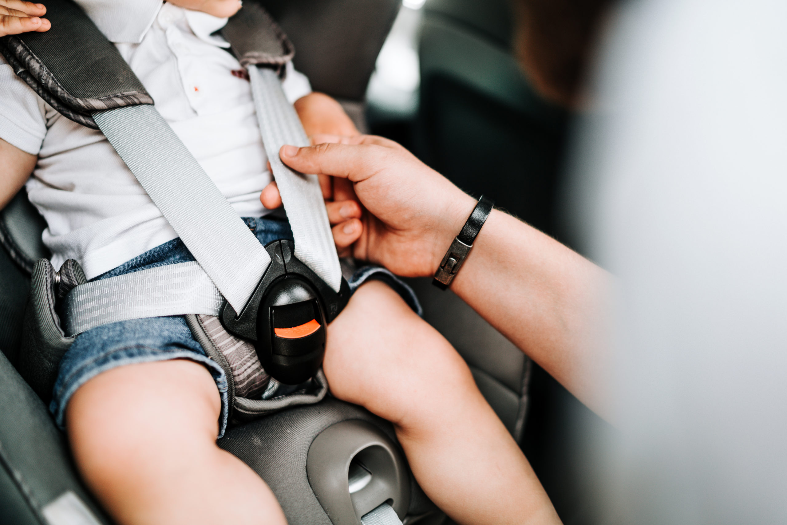 child car seat with baby inside, seatbelt and safety