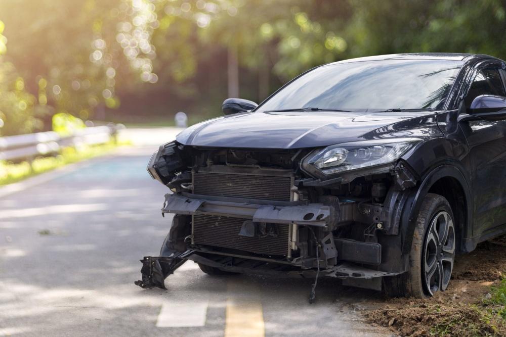 black car on side of road with damaged front