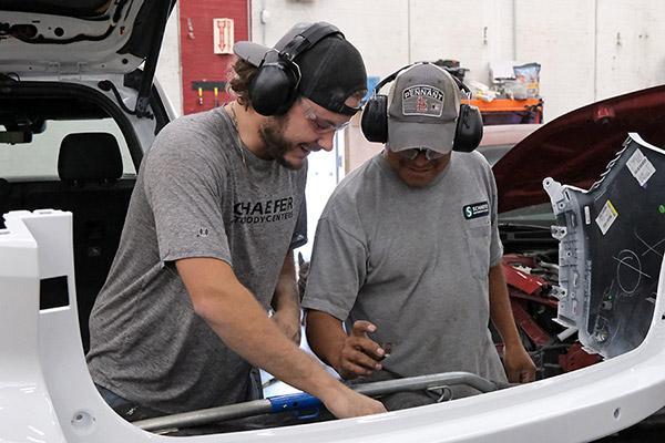 Apprentice works on a fender with journeyman