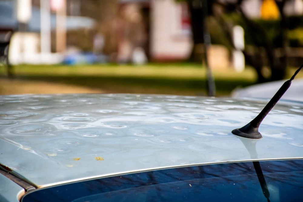 Car roof damaged by major hailstorm hailstones Car insurance repair dents Dented car rooftop | Schaefer Autobody Centers car roof damaged by hail storm